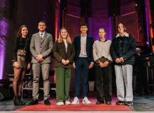 Mehrere Lehrlinge stehen auf der Bühne und lächeln.