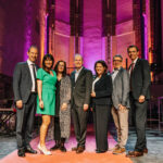 Personen stehen auf einer Bühne.