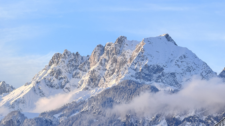 Der Wilde Kaiser trotzt den Wolken. Zwischen Sehnsucht nach Schnee und neuen Wegen jenseits der Piste bleibt Tirols Winterwelt trotzdem ein Fixstern für viele Gäste. (C) iStock / Getty Images Plus / Felix Gerber