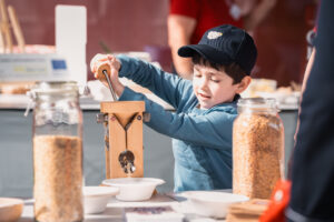 Ein Kind mahlt Körner zu einem Pulver.