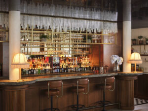 Eine Bar aus dunklem Holz. Kleine Lampen leuchten an den Seiten.