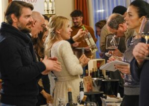 Eine Menschenmenge verkostet Weine. 