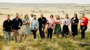 Eine Menschengruppe draußen lächelt in die Kamera.