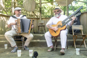 Zwei ältere Herren spielen Musik. Einer spielt Ziehharmonika, der andere Gitarre.