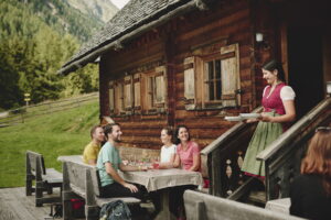 Wanderer sitzen an der Murauer Bierapotheke in der Ebenhandlhütte.