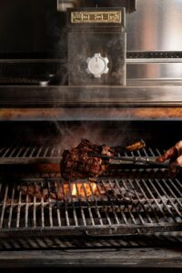 Josper-Grill in Aktion: Ein Steak wird über Holzkohle gegrillt und erhält dadurch die charakteristische Rauchnote.