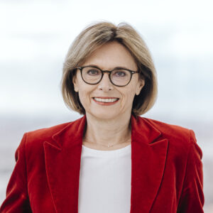 Portrait von Susanne Kraus-Winkler. Sie trägt eine Brille und einen roten Blazer.